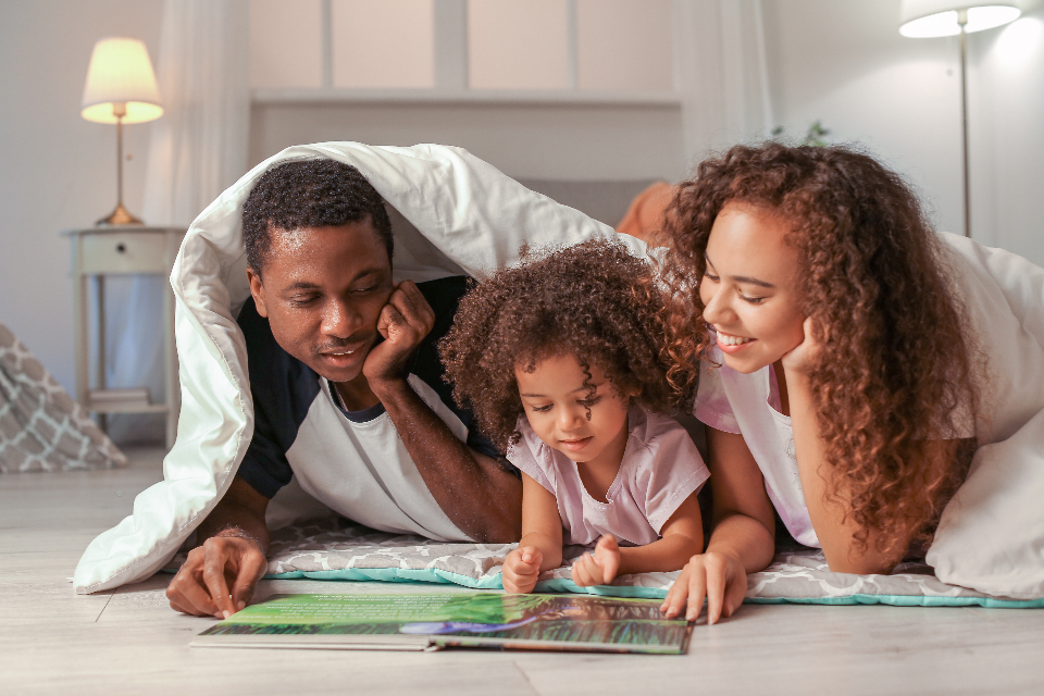 Parents and their daughter reading together at home